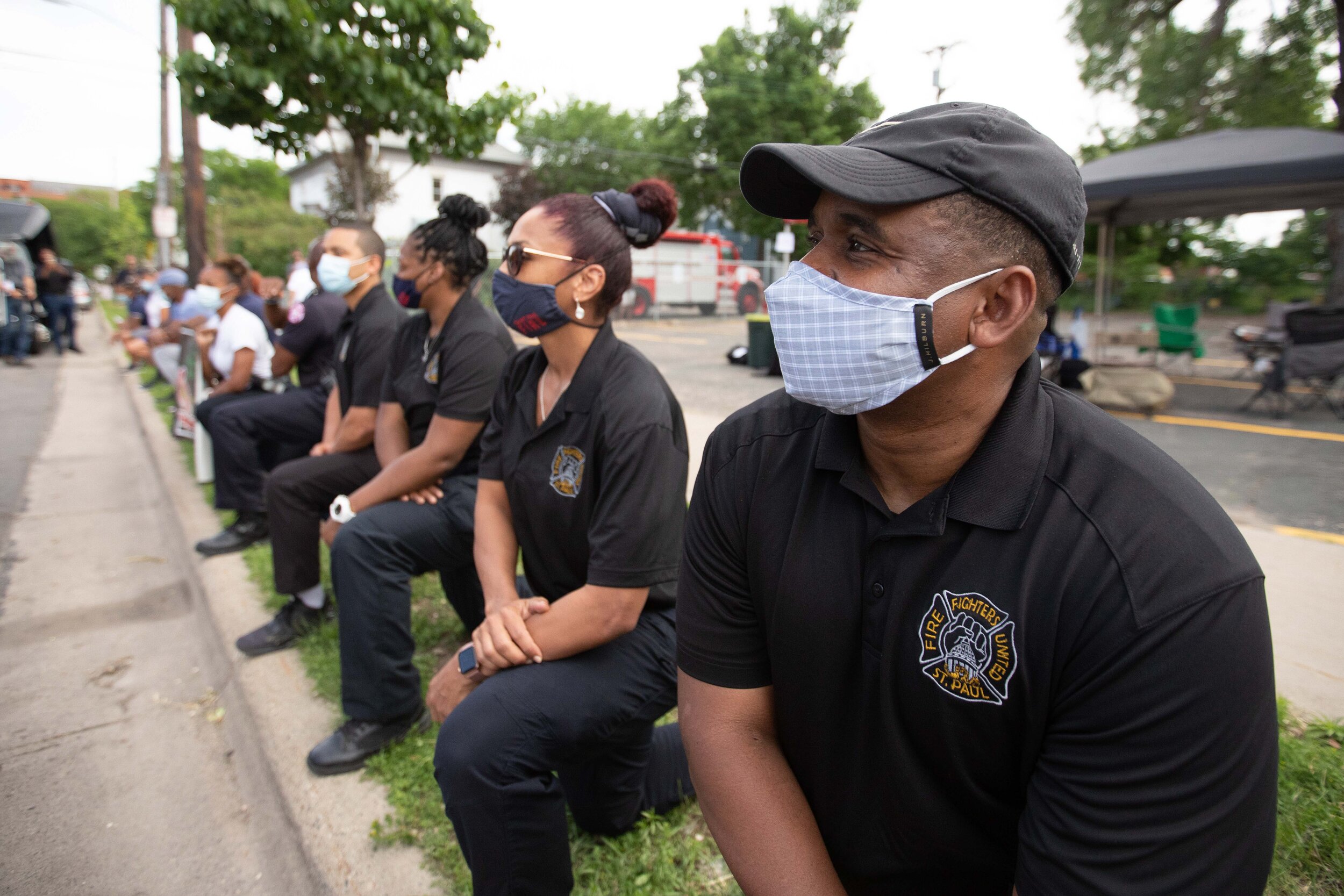  Firefighters take a knee in honor of George Floyd as the hearse containing his casket drives by at a memorial for George at North Central University on Jun 4, 2020. 