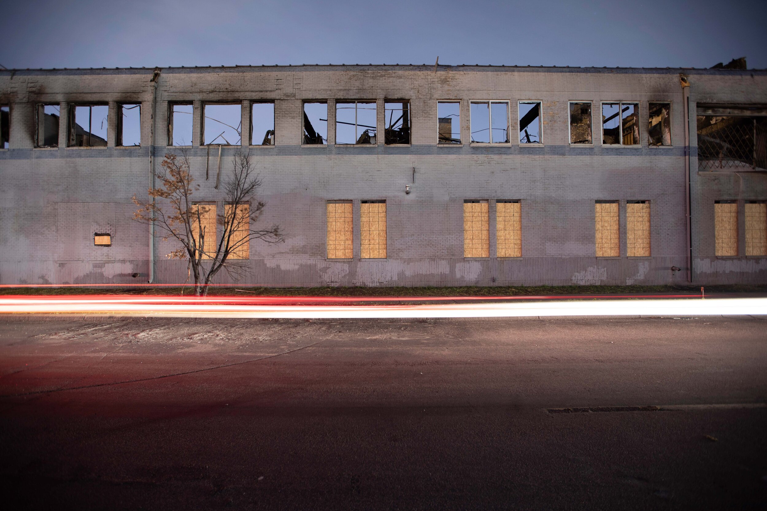  Light trails from a vehicle light up the street as a burned out and destroyed building sits in ruin behind it. During the riots that broke out in Minneapolis this building was set on fire in Minneapolis, Minnesota on Jun 8, 2020. 