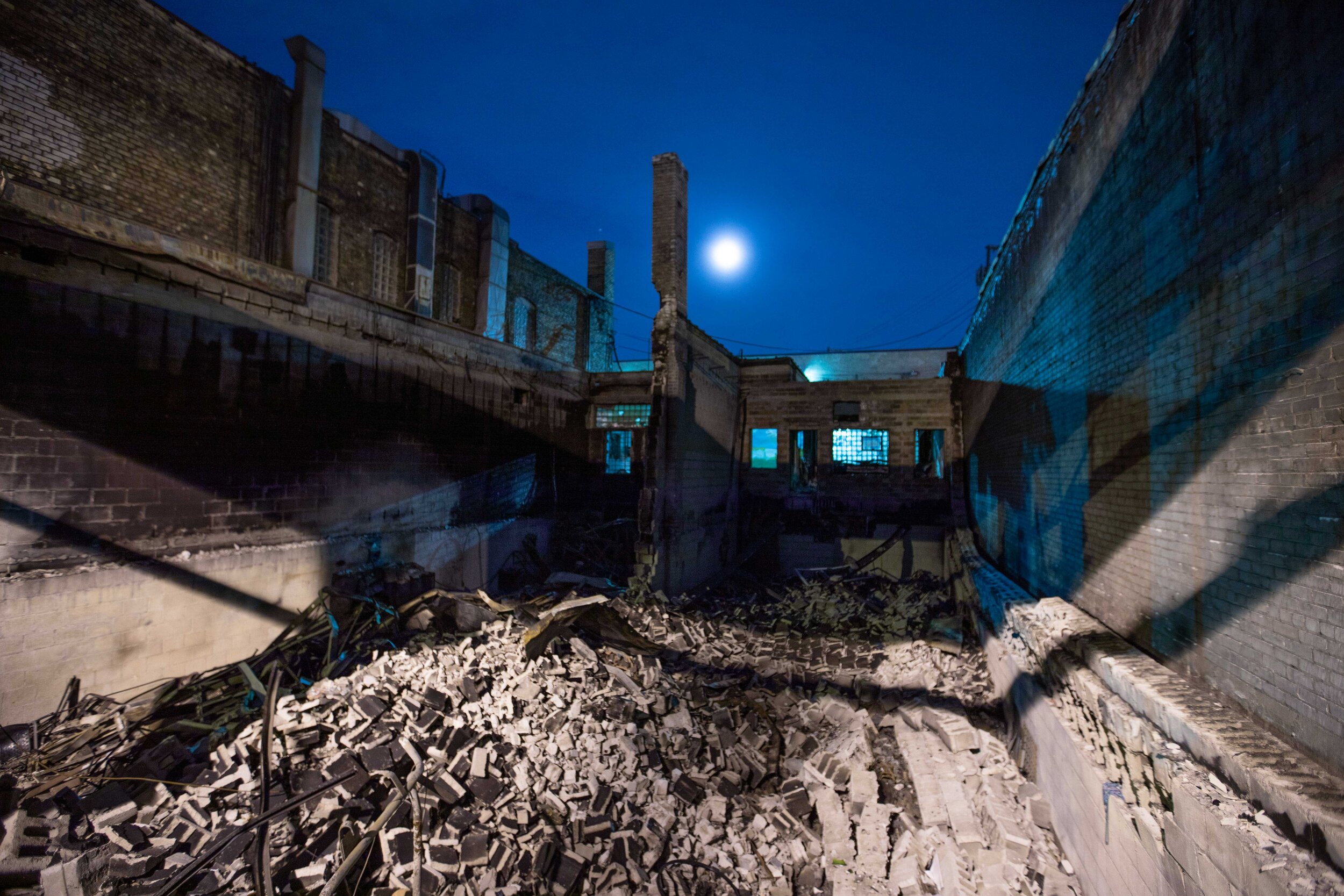  A destroyed building sits lit by street lights with the moon in the sky behind it. After riots broke out over the police killing of George Floyd this building was set on fire in Minneapolis, Minnesota on Jun 8, 2020. 