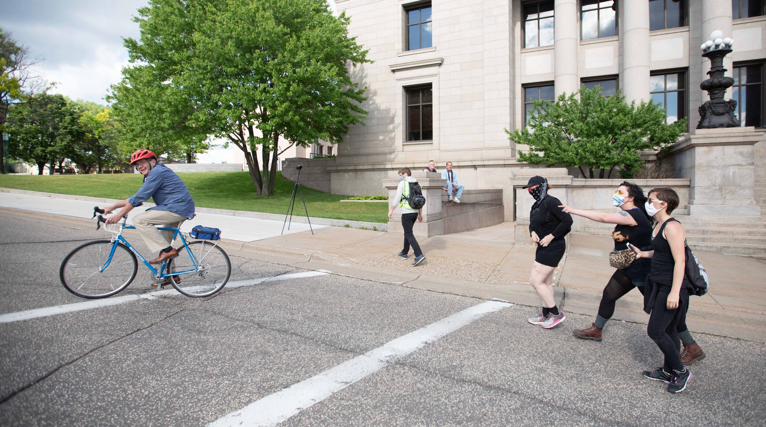  After telling activists, "they can't do whatever they want," a man on a bike gets screamed at as he rode by the torn down statue of Christopher Columbus on the State Capitol grounds in Saint Paul, Minnesota on Jun 10, 2020. 