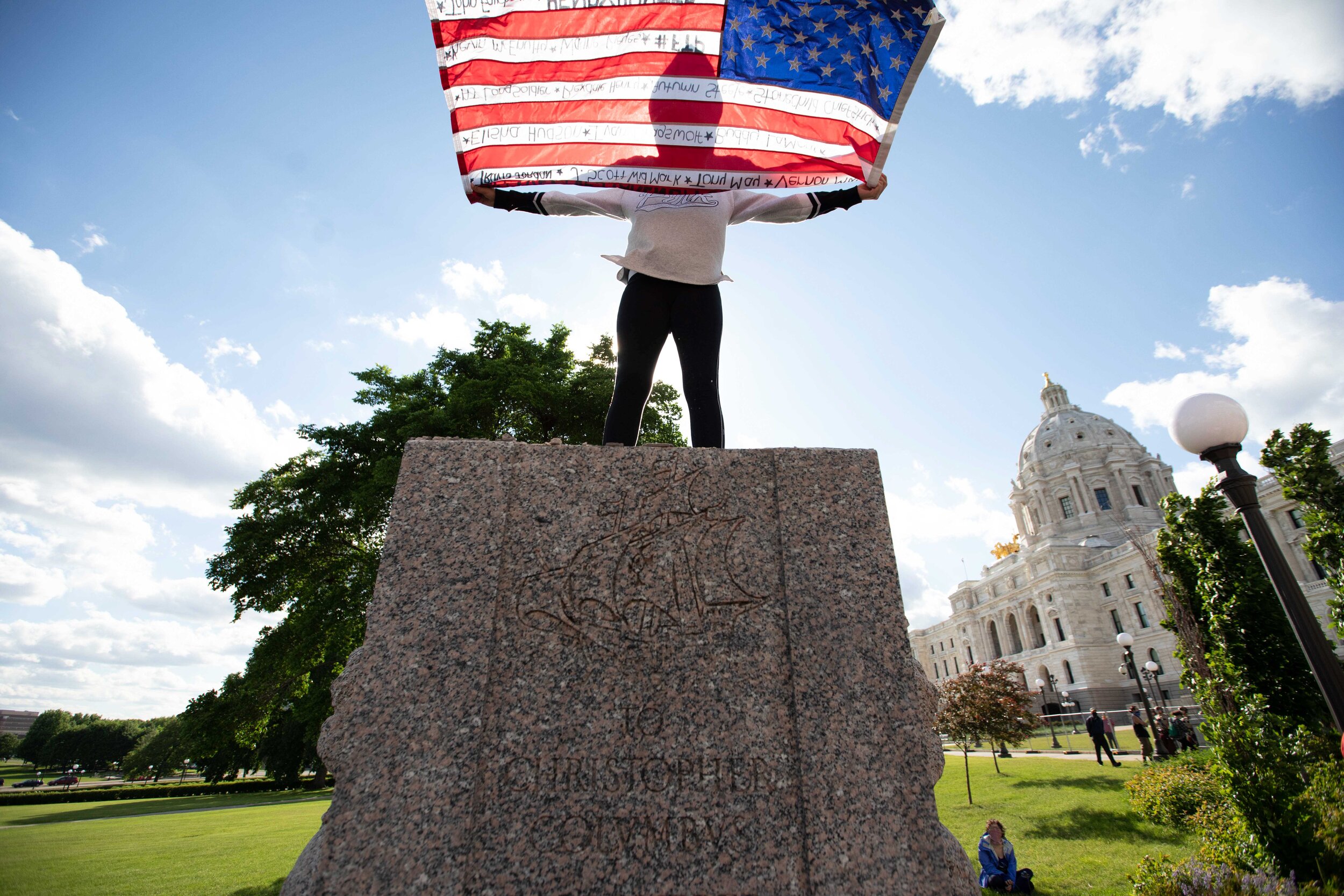  Holding a flag up, an activist stands where the Christopher Columbus statue stood minutes earlier before it was torn down in Saint Paul, Minnesota on Jun 10, 2020. 
