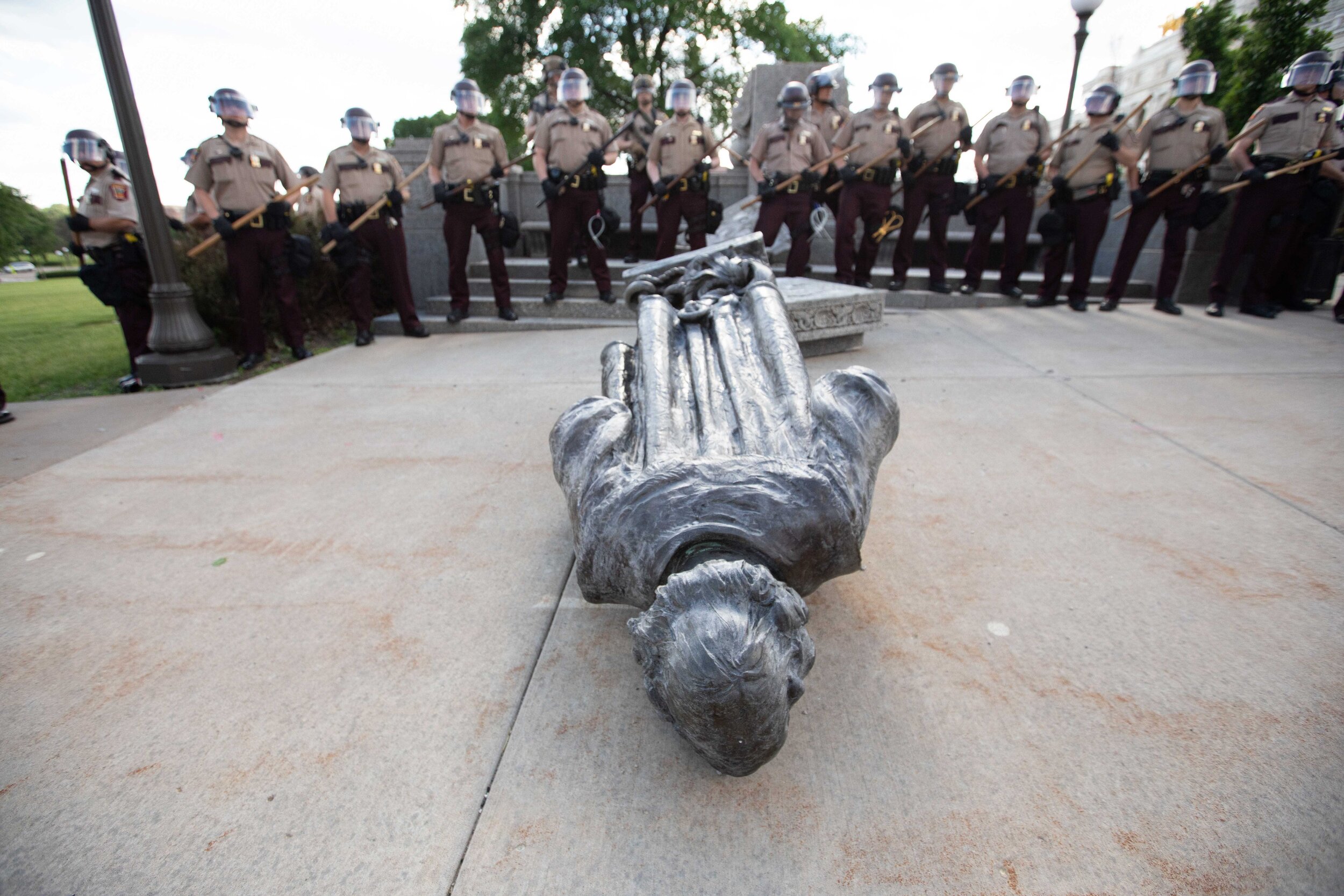  The Minnesota State Troopers stand guard behind the recently torn down Christopher Columbus statue on the grounds of the State Capitol on Jun 10, 2020. 