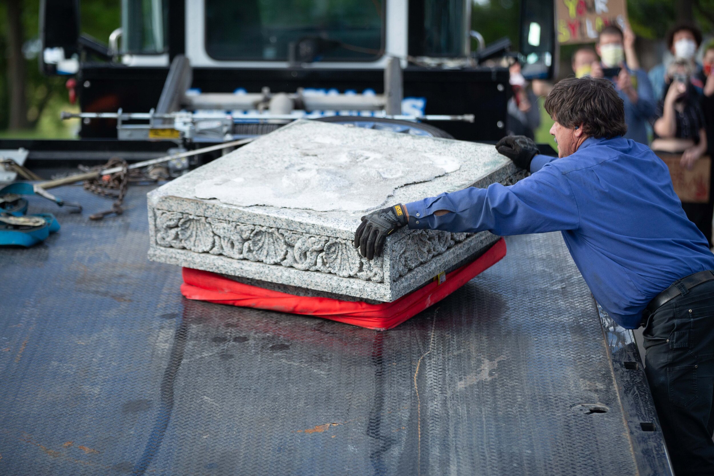  Workers put parts of the pedestal that once held the statue of Christopher Columbus on the grounds of the State Capitol in Saint Paul, Minnesota on Jun 10, 2020. 