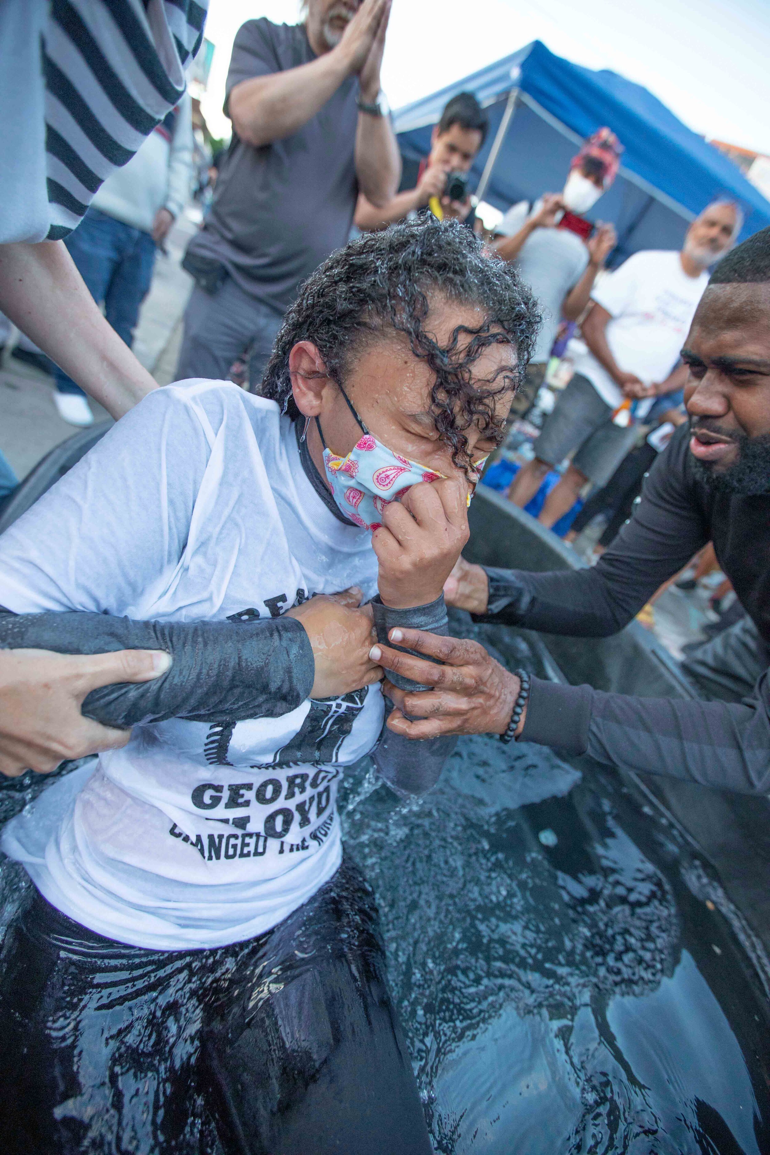  Sade Strong (left) is baptised on the street of George Floyd Square as Pastor Joshua Giles (right) pulls her out of the water in Minneapolis, Minnesota on Jun 13, 2020. 