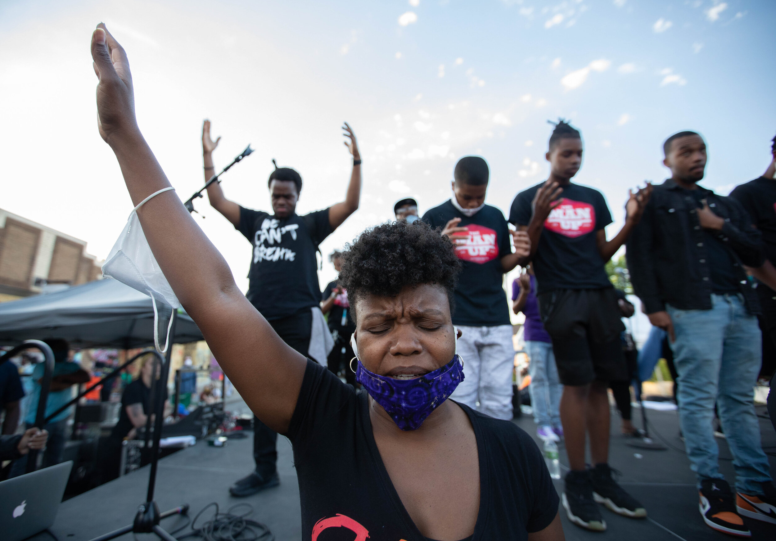  A pastor puts her hand in the air as a group of community members pray together at the memorial site for George Floyd on Chicago Ave in Minneapolis, Minnesota on Jun 14, 2020. 