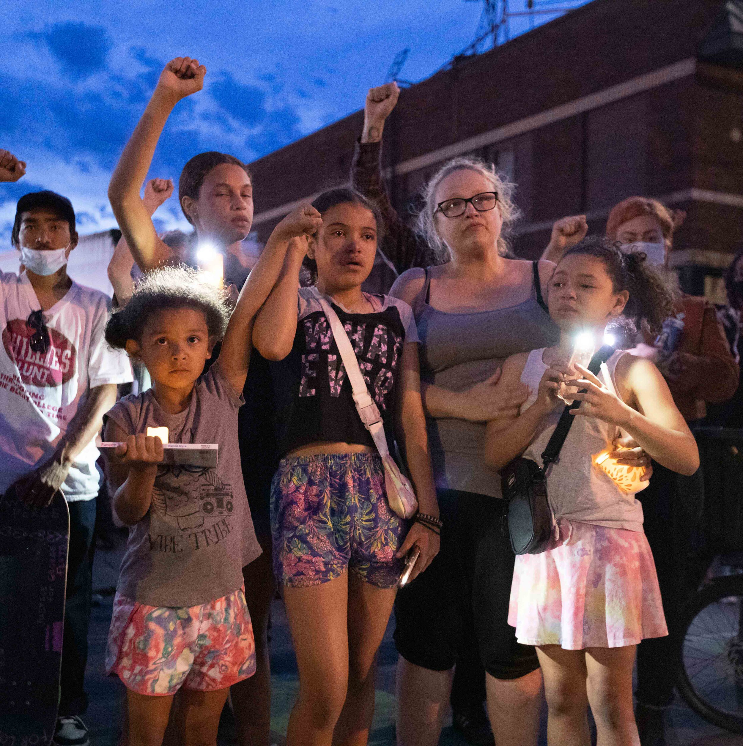  A group of children raise their fists in the air while mourning the loss of George Floyd at the site of his memorial in Minneapolis, Minnesota on Jun 14, 2020. 