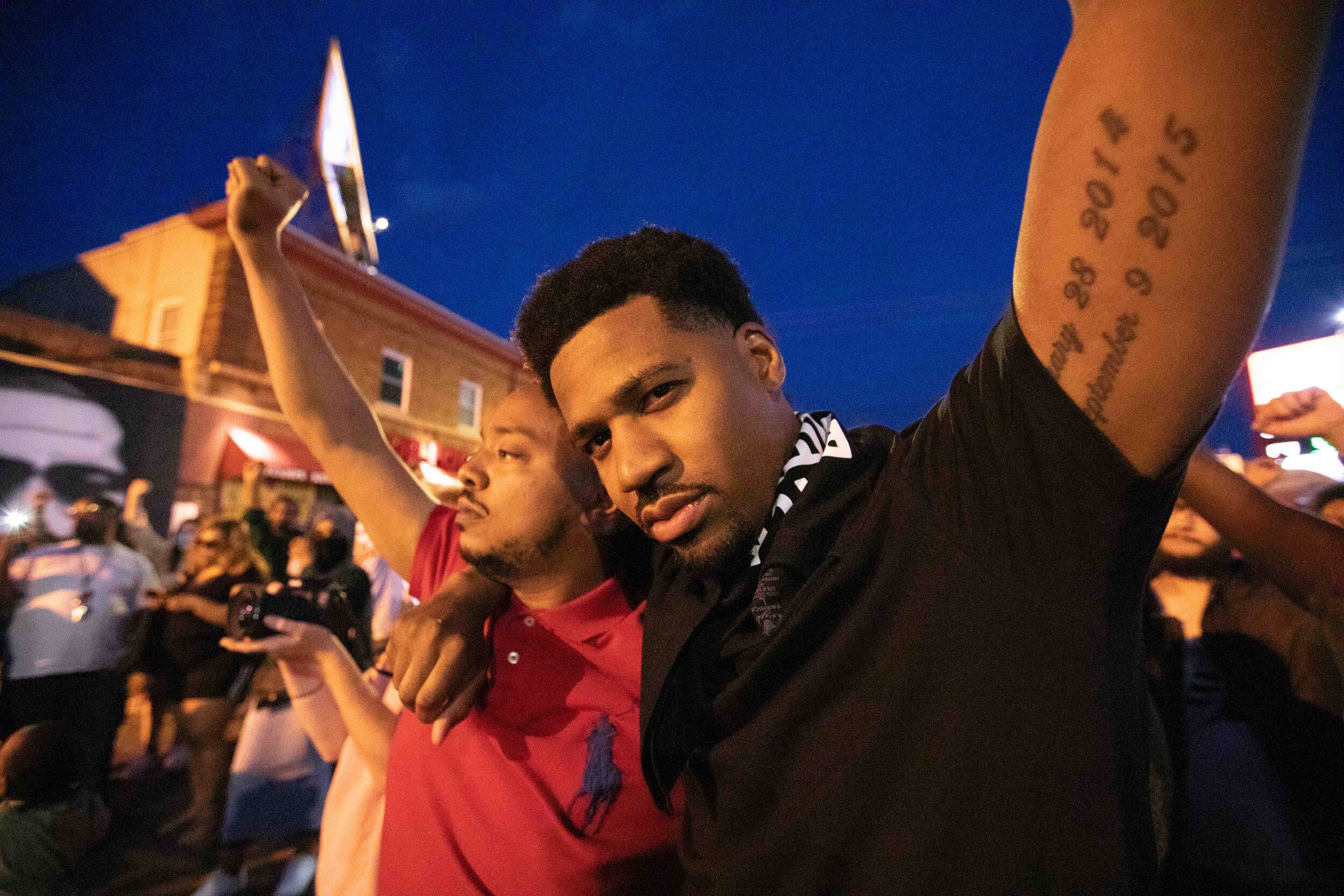  Community members raise their fists in the air while mourning the loss of George Floyd at the site of his memorial in Minneapolis, Minnesota on Jun 14, 2020. 