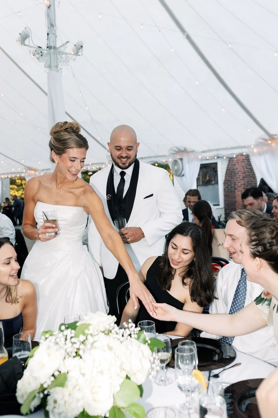 Candid wedding moments, happy bride shows her wedding ring to friends