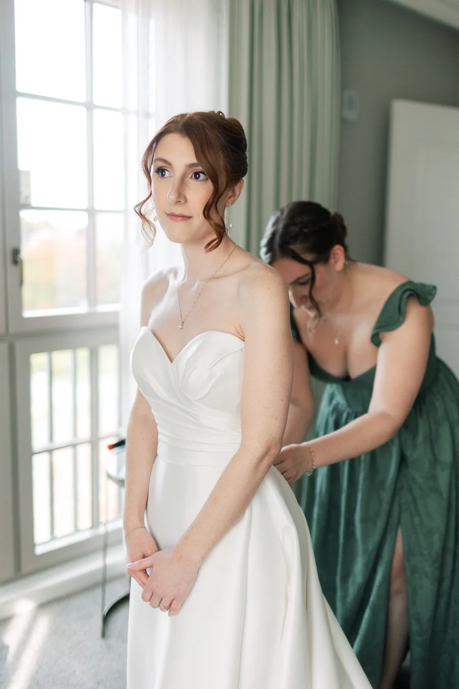 Bride Ali getting in to dress for her wedding at Delamar West Hartford in Connecticut