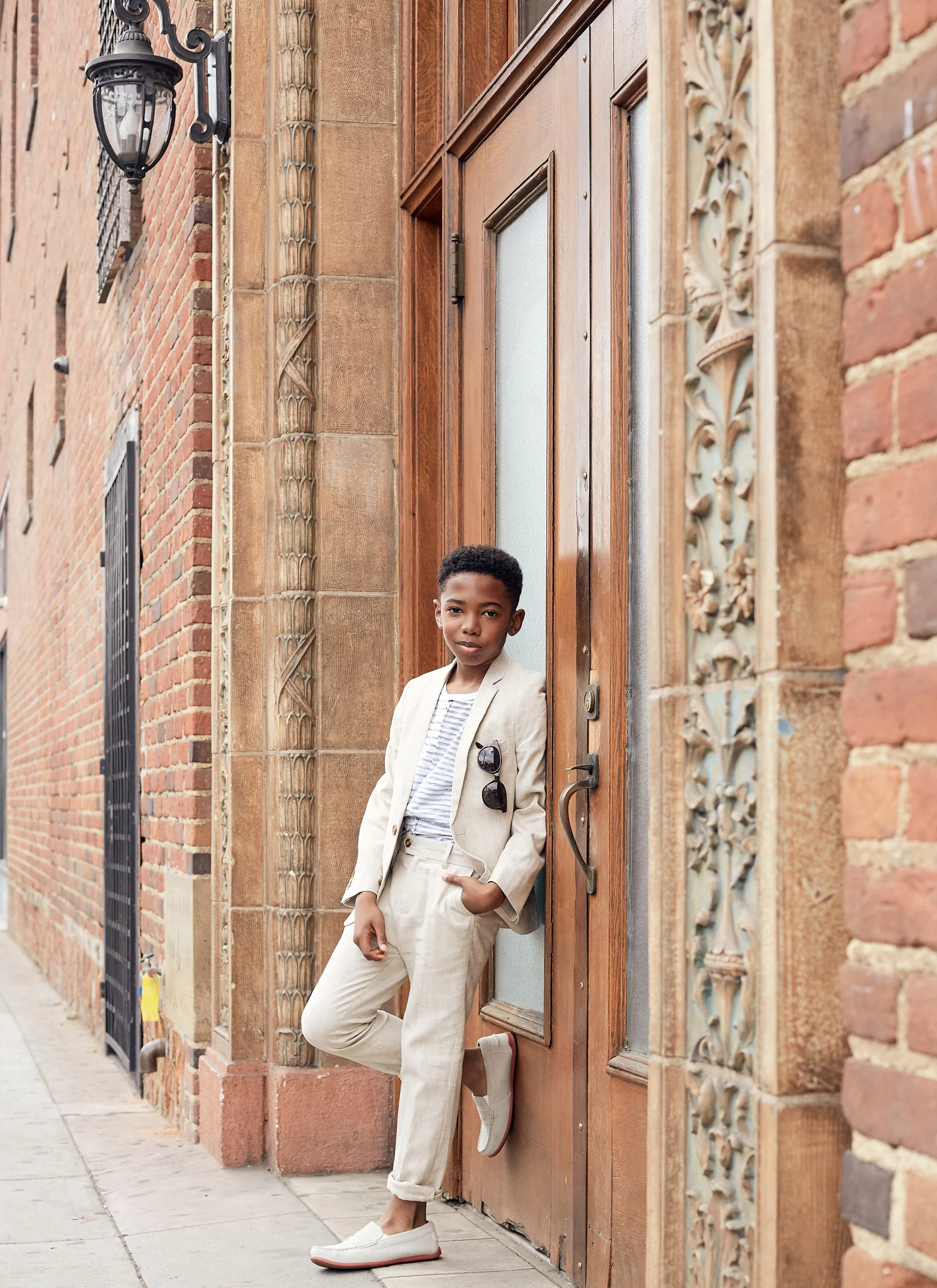 Seth Carr wearing Suit: Appaman T-shirt: Stem Loafers: Florsheim Sunglasses: Retrosuperfuture Wardrobe - Angelique Fortuna Grooming - Renee Loiz Photograph - Ryan Pavlovich