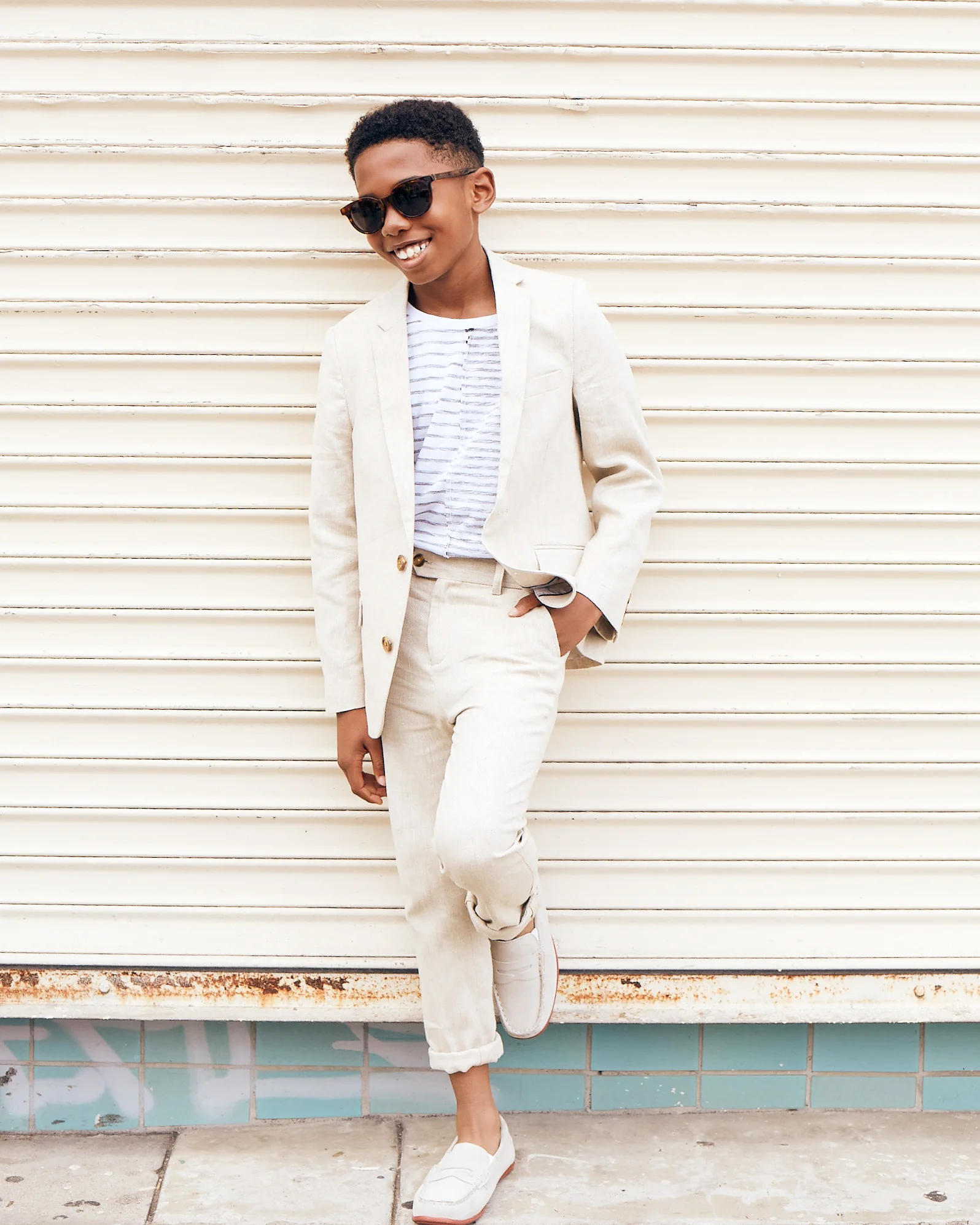 Seth Carr for Posh Kids Magazine wearing: Suit: Appaman T-shirt: Stem Loafers: Florsheim Sunglasses: Retrosuperfuture Wardrobe - Angelique Fortuna Grooming - Renee Loiz Photograph - Ryan Pavlovich