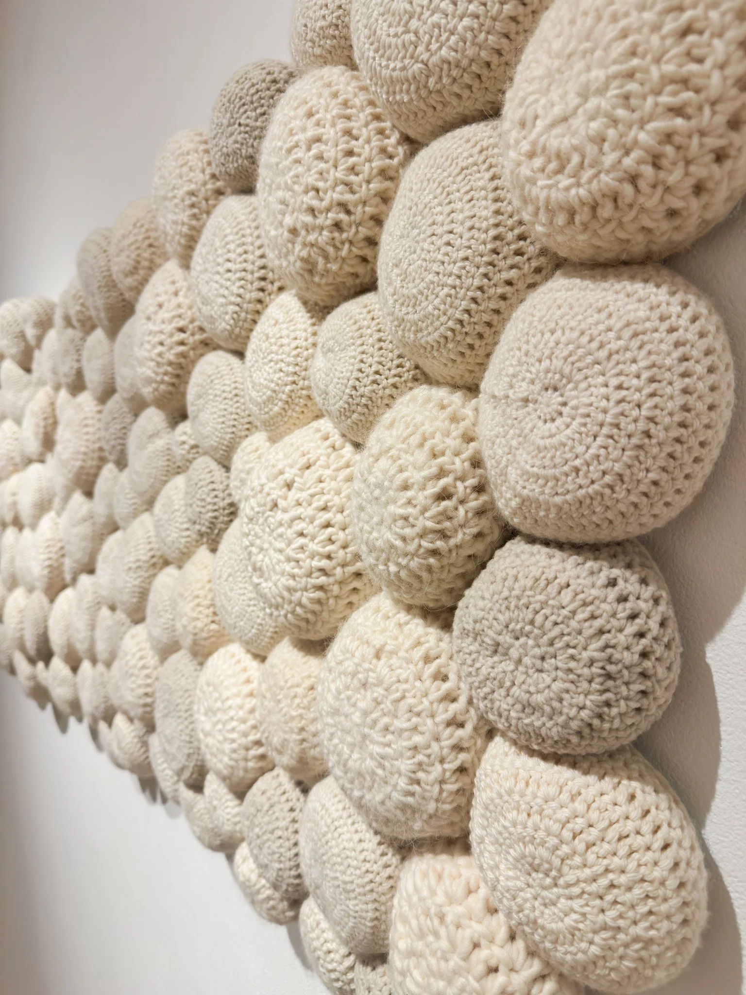 Redeemed, 2022, crocheted wool yarn, wool fill, reclaimed cotton domestic fabric backing, 29”h x 70”w x 4”d