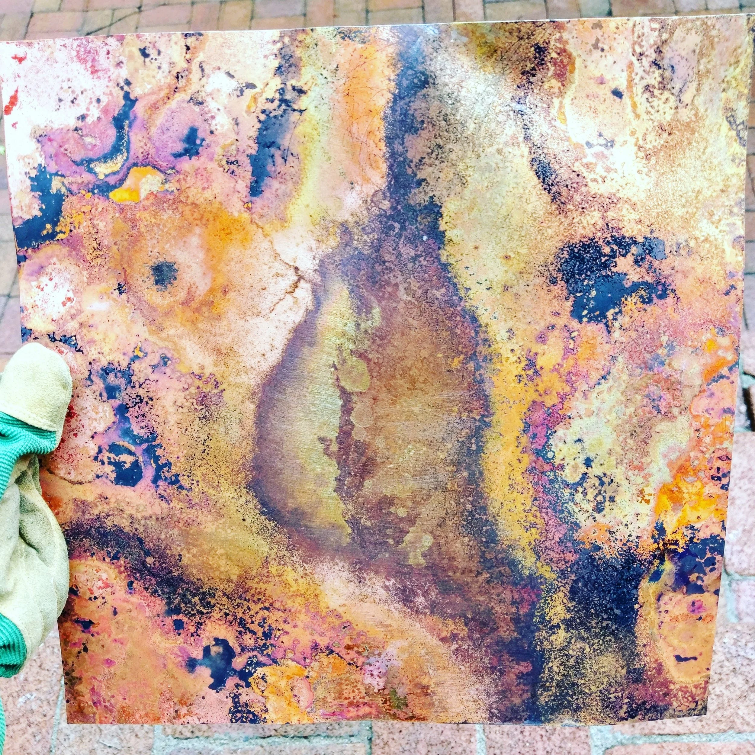 This patina was achieved by applying salt to a sanded and cleaned copper surface. I then propped them up on soft kiln bricks, and torched the metal from below with MAP gas. As the salt bubbles and dissolves I continue to add more until the entire surface has a sooty, black look. Sanding through the soot revealed beautiful warm reds, yellows, and orange tones.