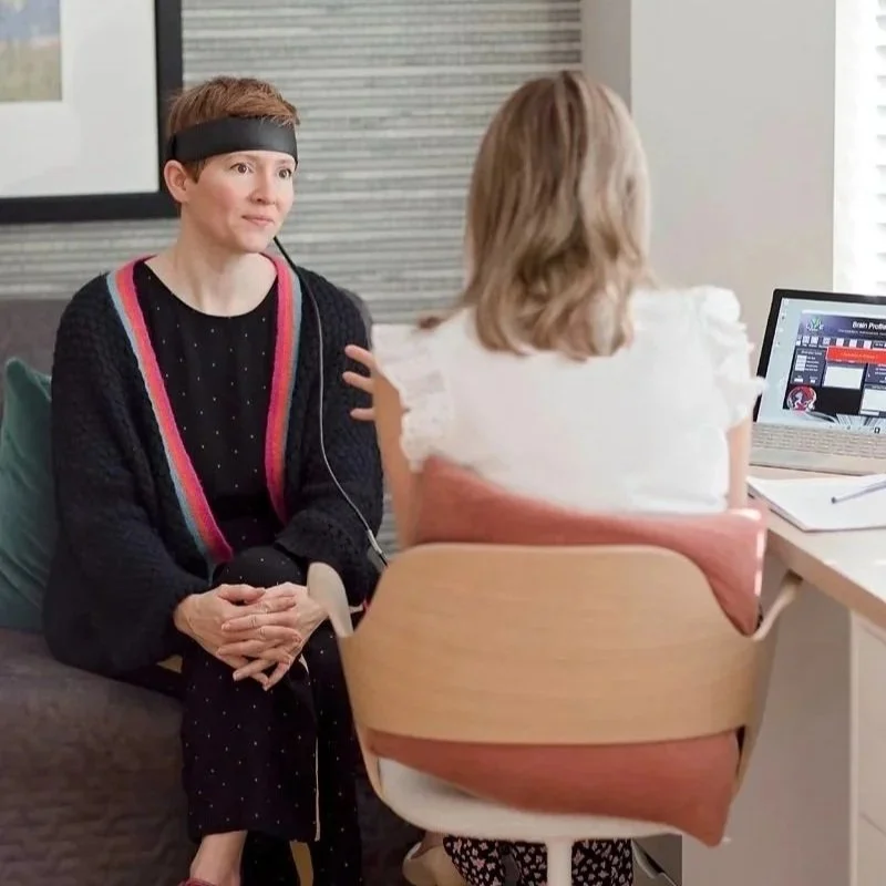 Client wearing biofeedback headband during consultation with practitioner in Scotland