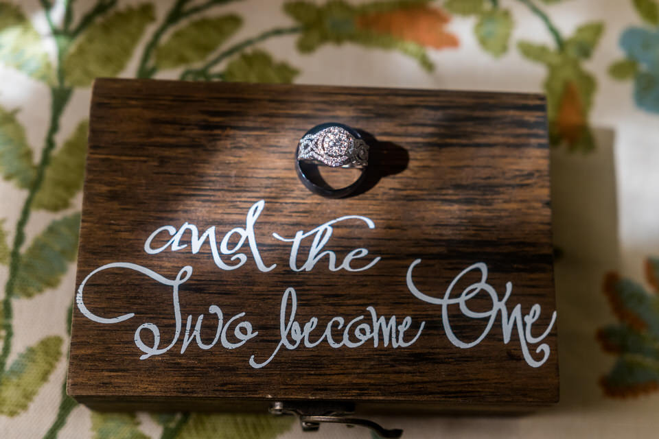  A set of wedding rings sits in a sunbeam on a box that says Mr and Mrs 