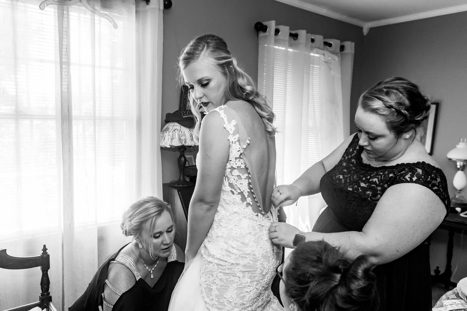  A bride puts on her wedding dress in her parents bedroom before heading to the ceremony 