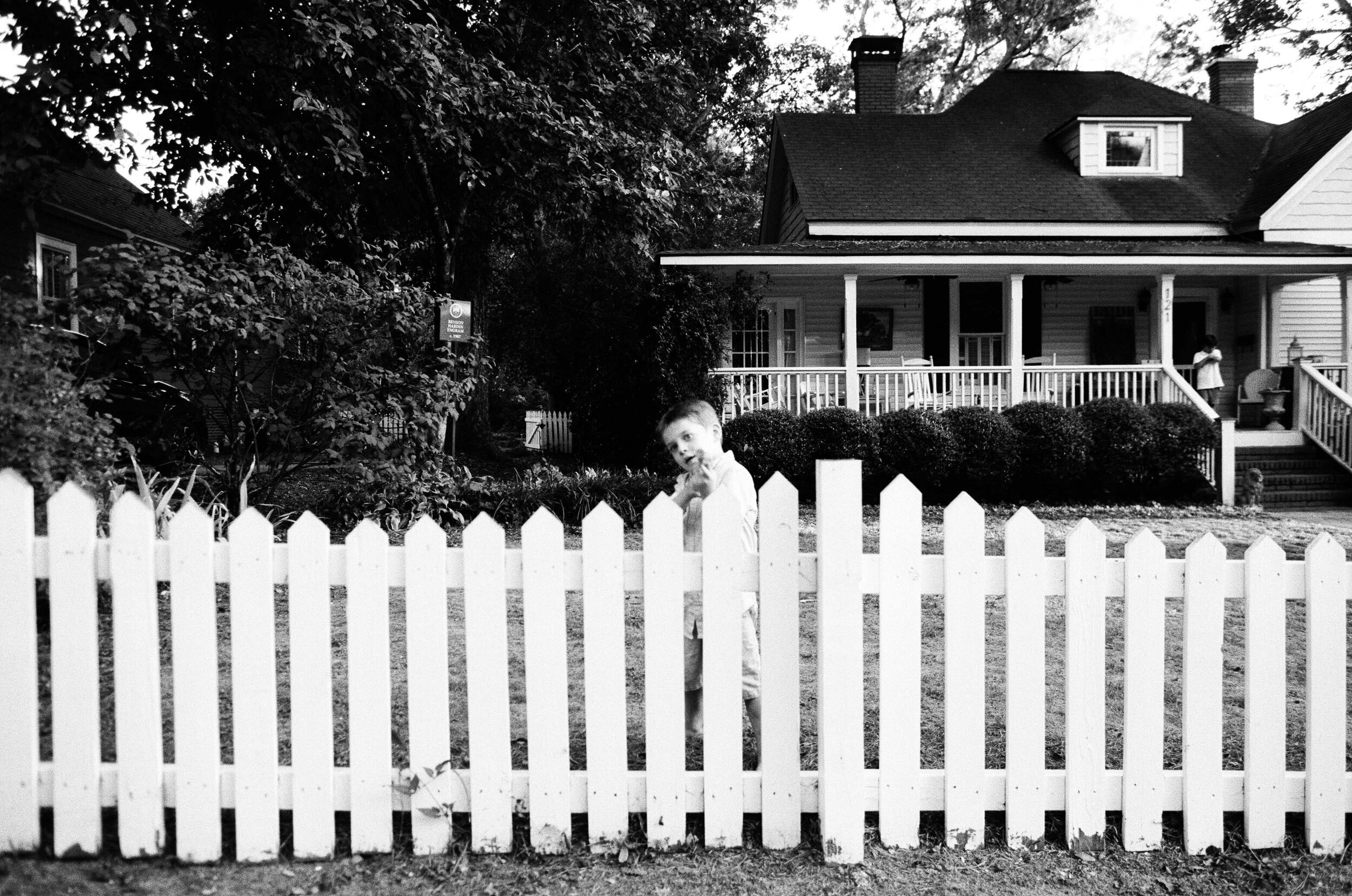 boy playing in front of classic southern home