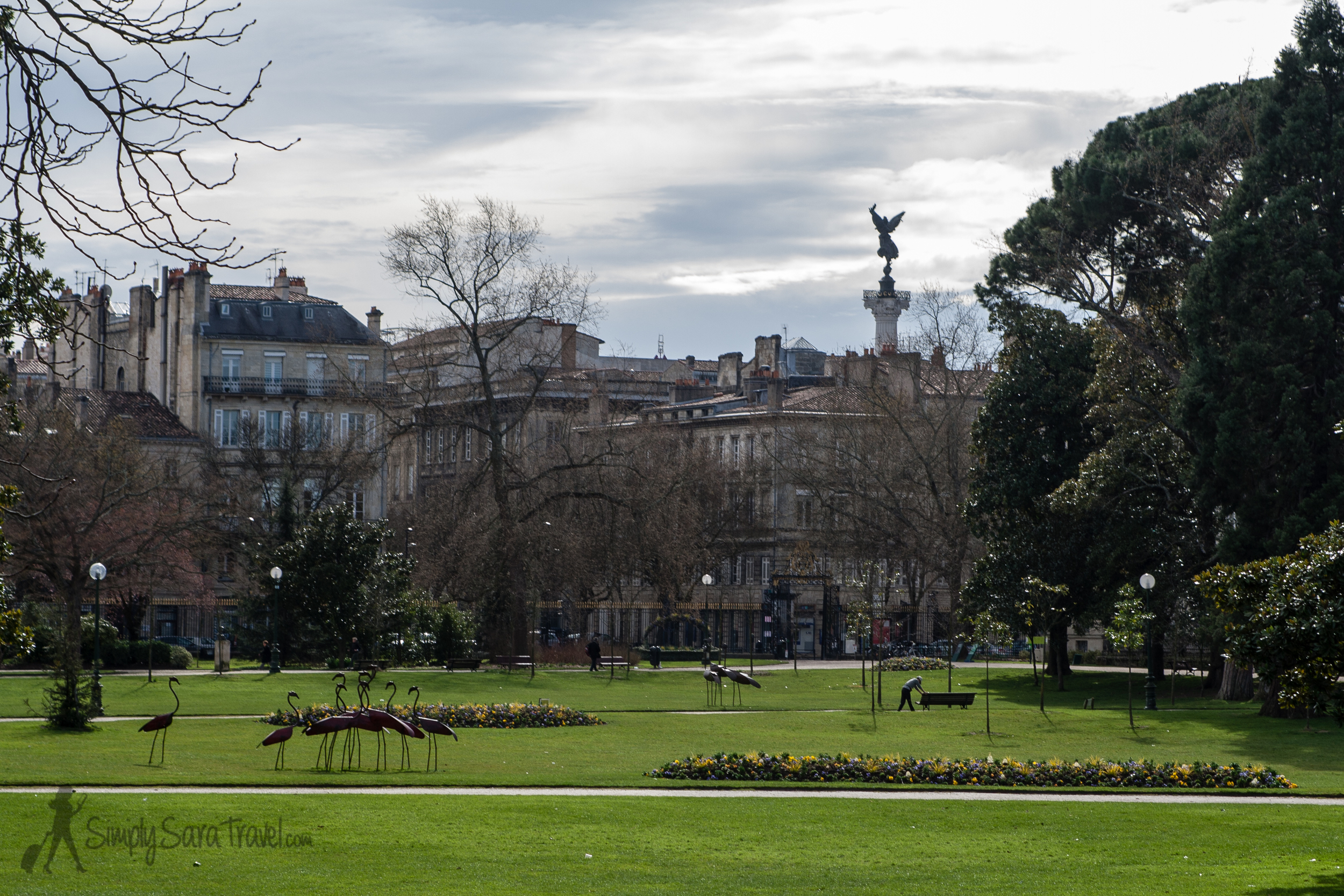 The public garden with a view of the Monument aux Girondins rising up behind the buildings