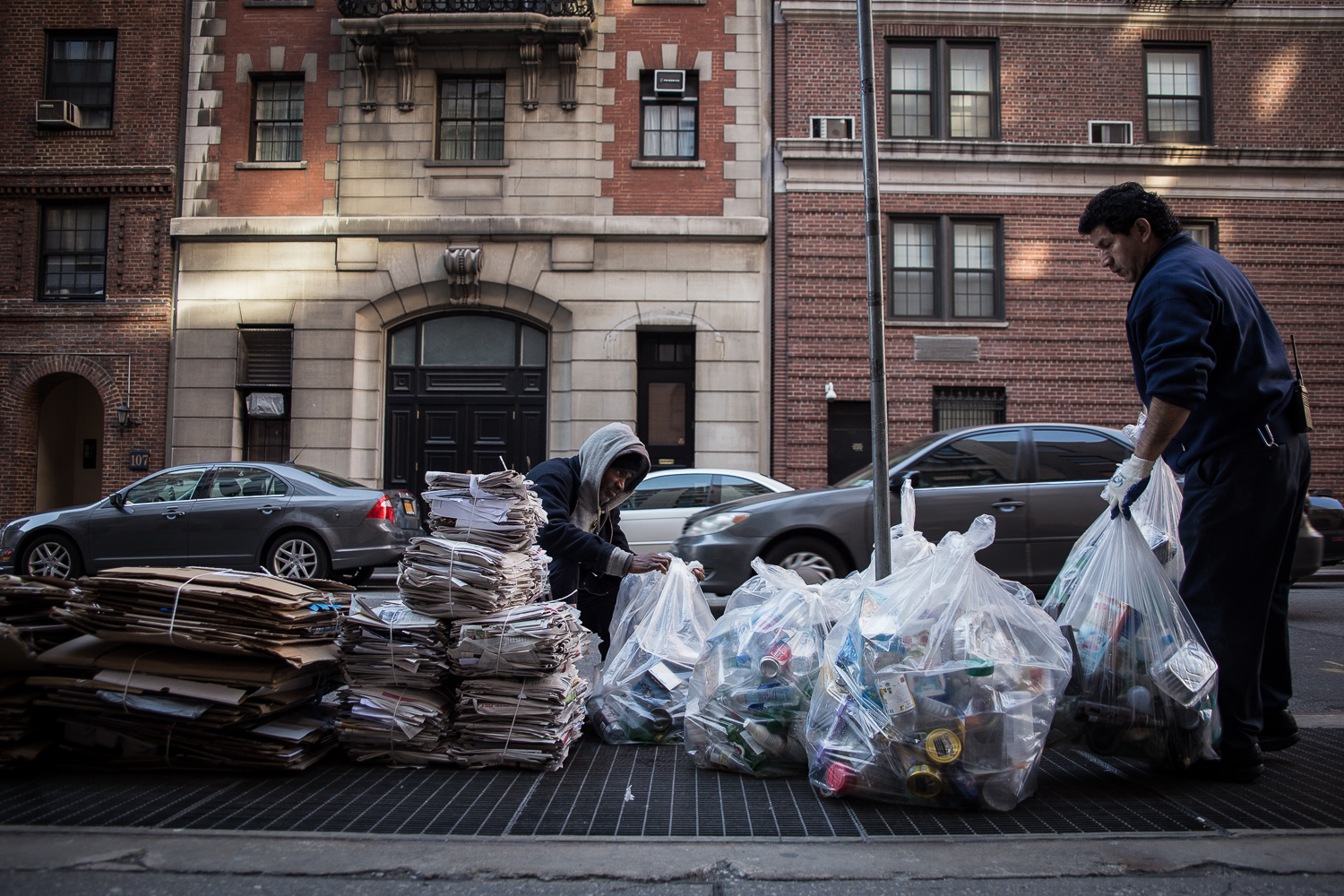  Butler sorts through recycling as a maintenance man carries out more bags. 