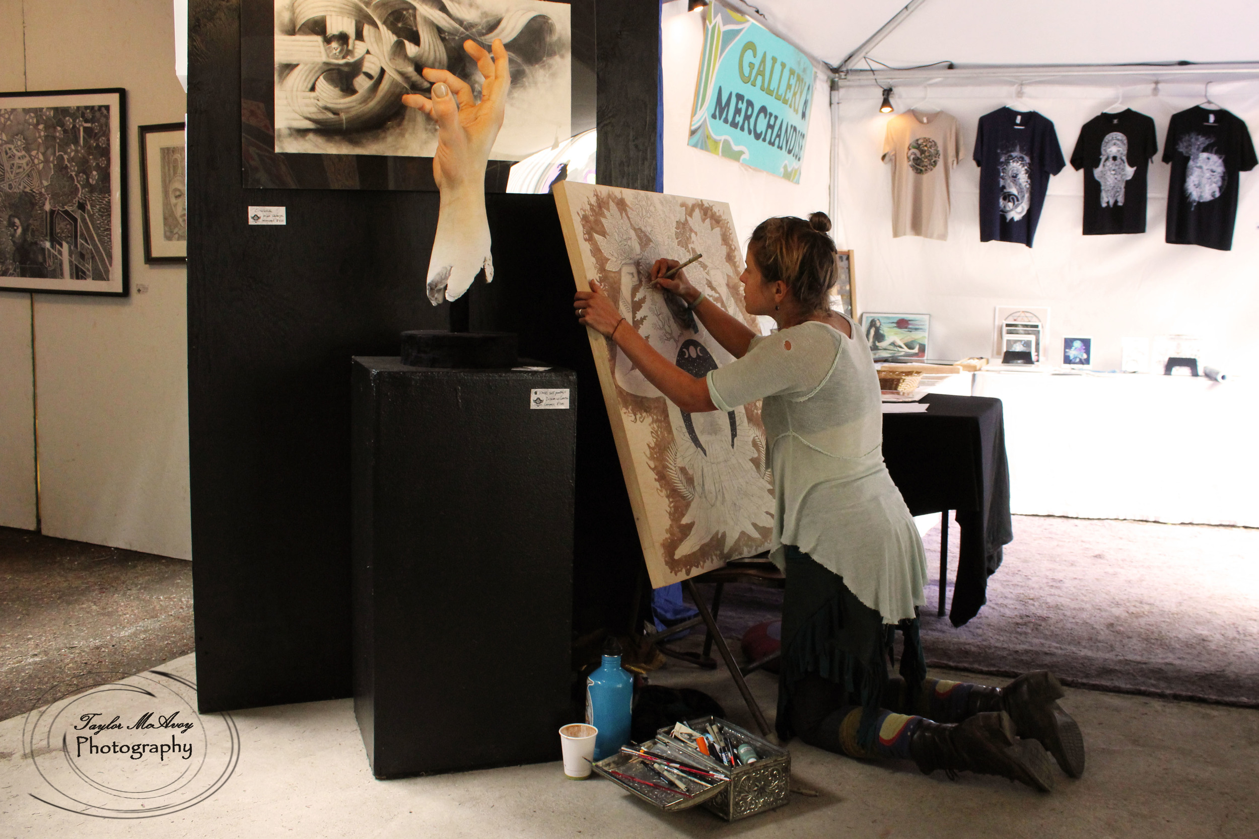  Artist Rose Drummond finishes a work in progress in the art tent full of paintings, abstract art and sculpture by Cascadian artists.&nbsp; 