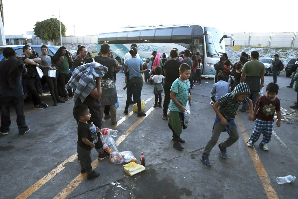 Inmigrantes que serán trasladados de Nuevo Laredo a Monterrey. Foto tomada de la agencia AP (Marco Ugarte).