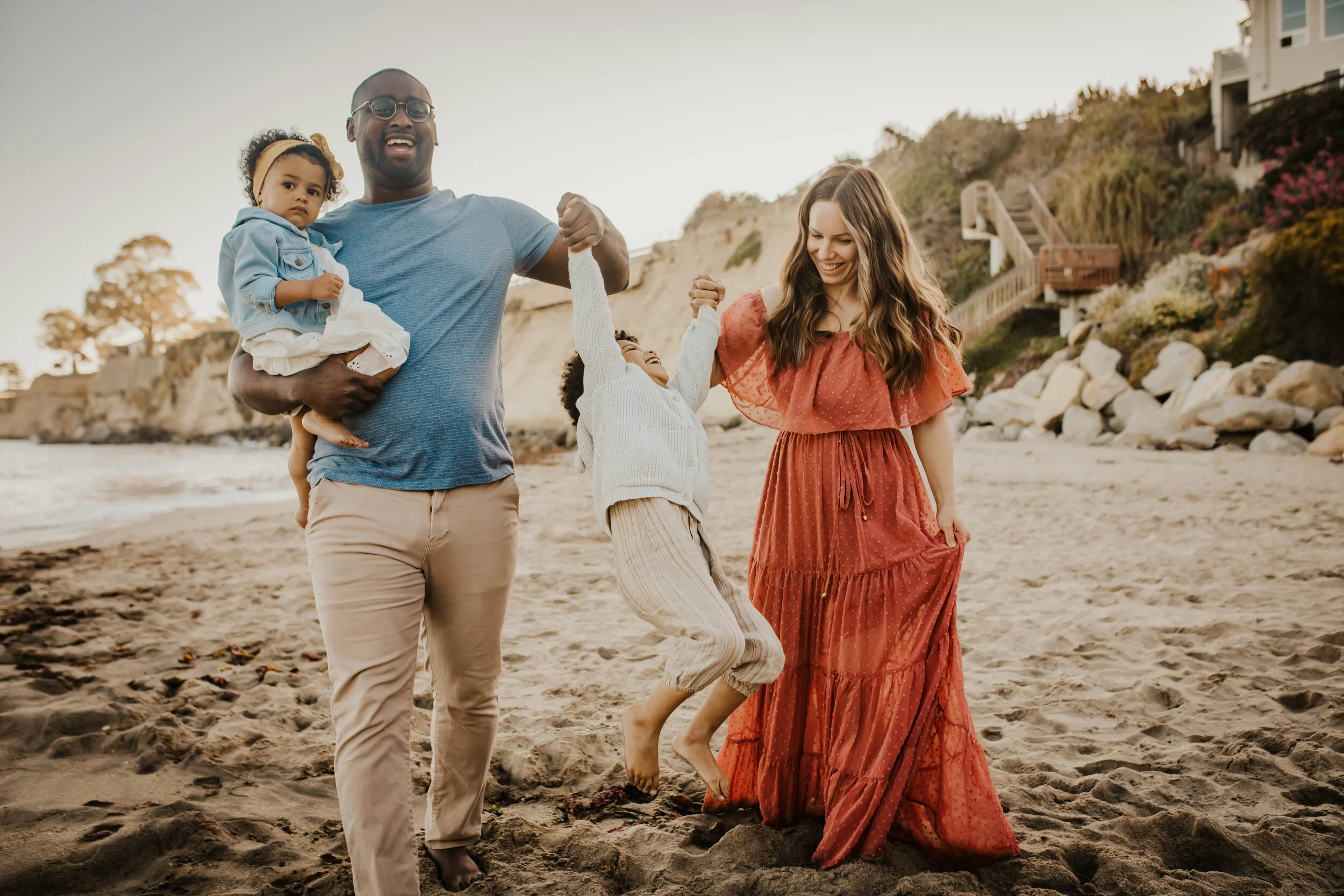 Image of family swinging happy child on the beach.jpg