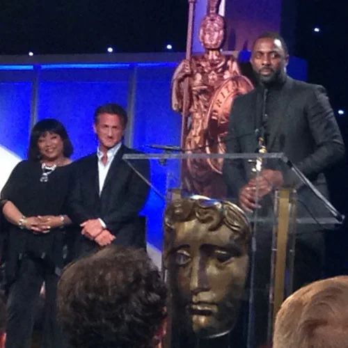 Zindzi Mandela and Sean Penn look on as Idris Elba makes his acceptance speech at BAFTA Los Angeles Britannia Awards