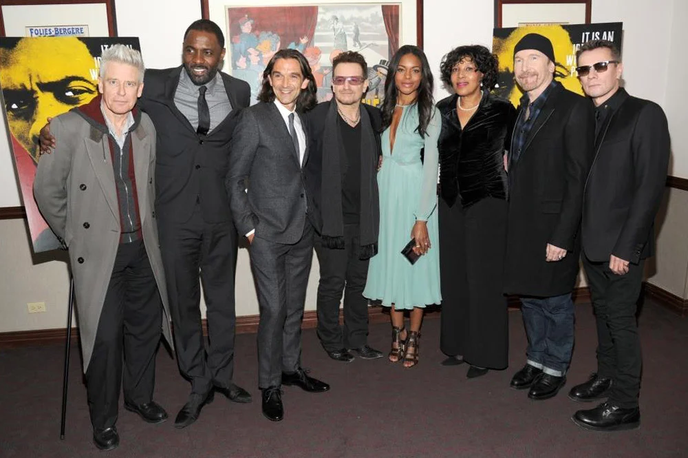 (L-R) Adam Clayton, Idris Elba, Justin Chadwick, Bono, Naomie Harris, Zenani Mandela, The Edge, and Larry Mullen, Jr. at the Ziegfeld Theatre in New York City / Bryan Bedder/Getty Images (p)