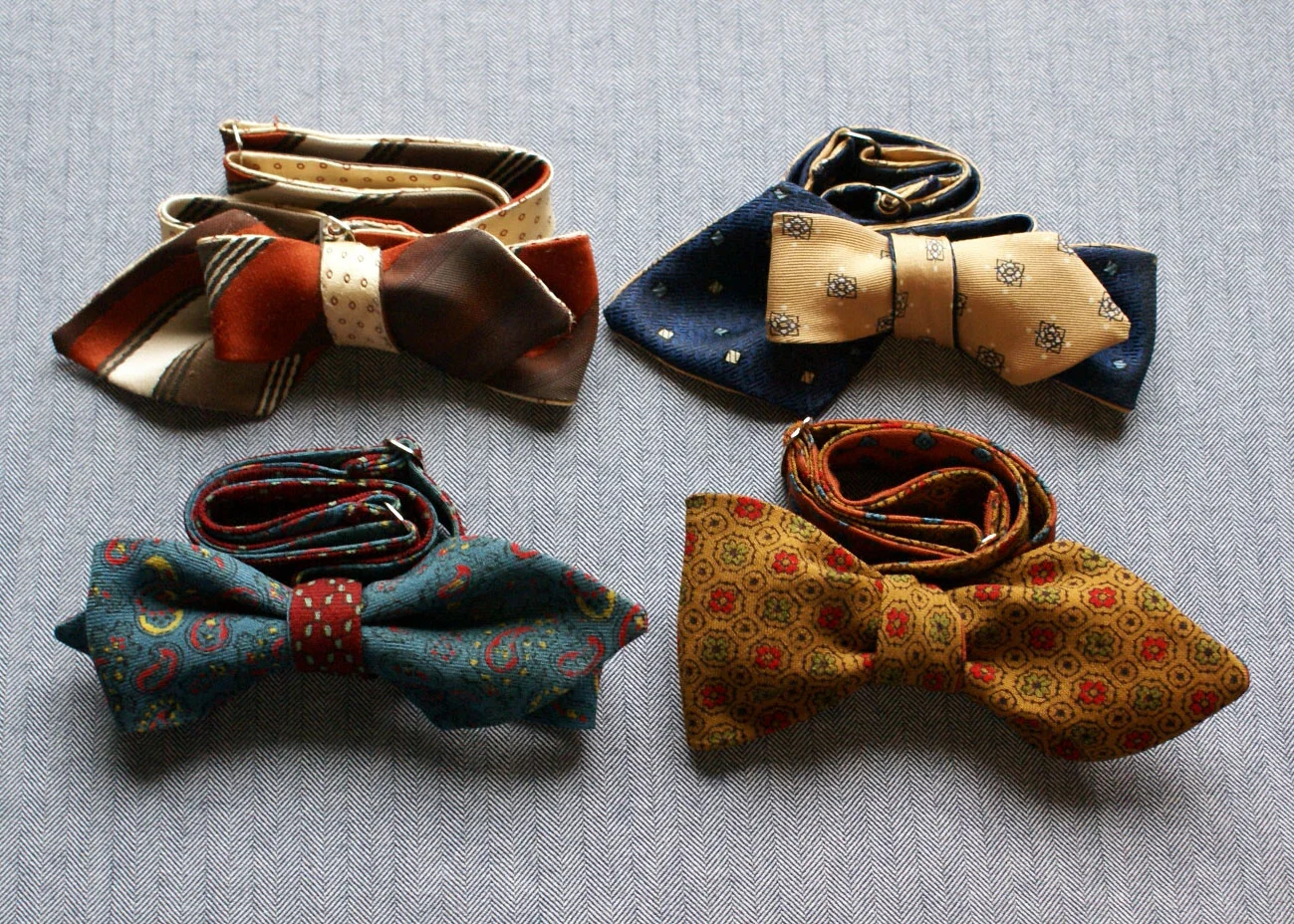 Up-cycled neck tie bow ties: each of these bow ties was once two separate neck ties, making them extraodinarily unique. Made from fine silks and woollens, this design embraces the past and makes use of would-be-discarded, still-good material. As this design is both double sided & double ended, it means the bow tie can be tied four different ways: four bow ties in one! 