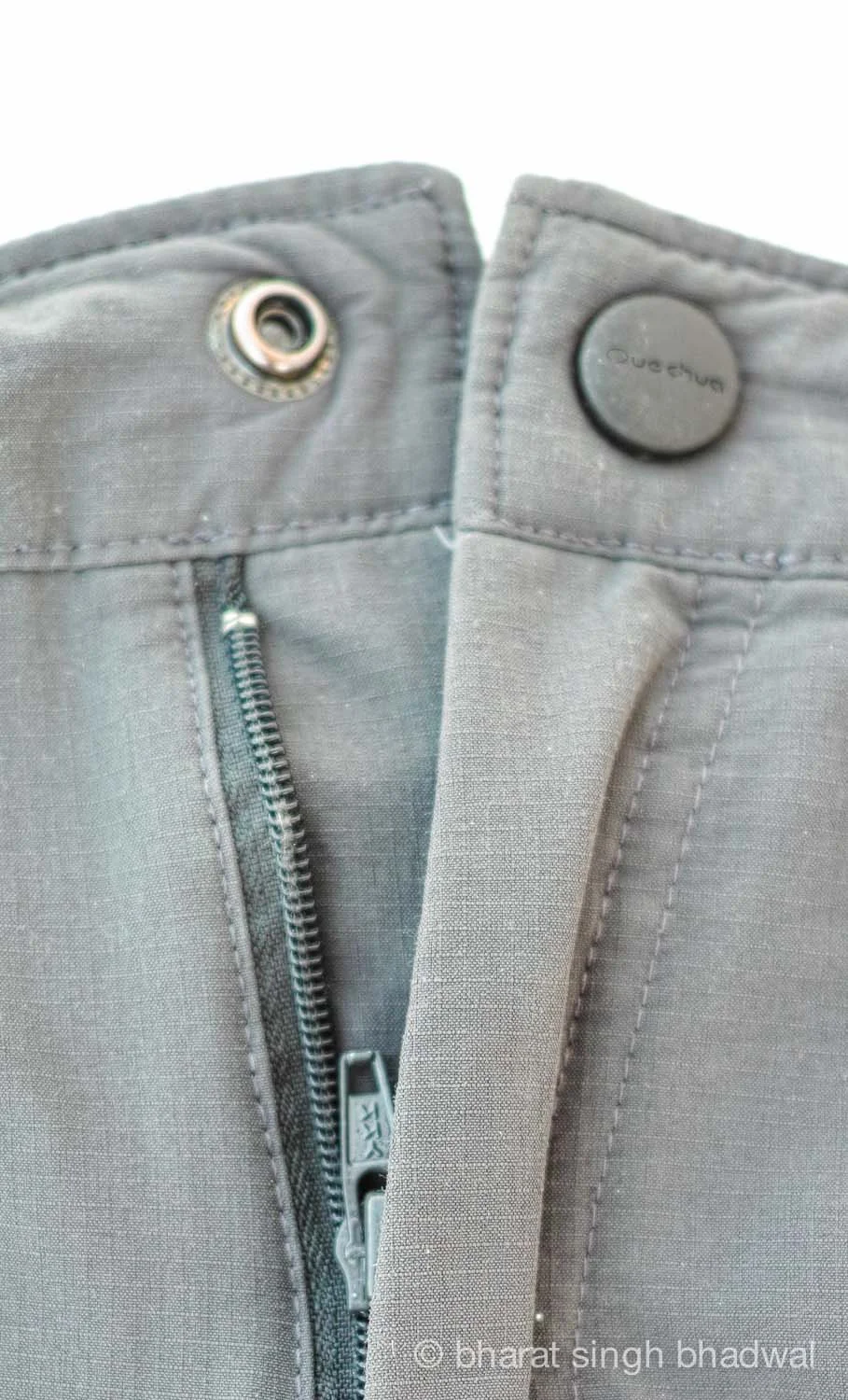 Front snap with subtle branding and YKK zipper. The ripstop fabric (small squares) is evident