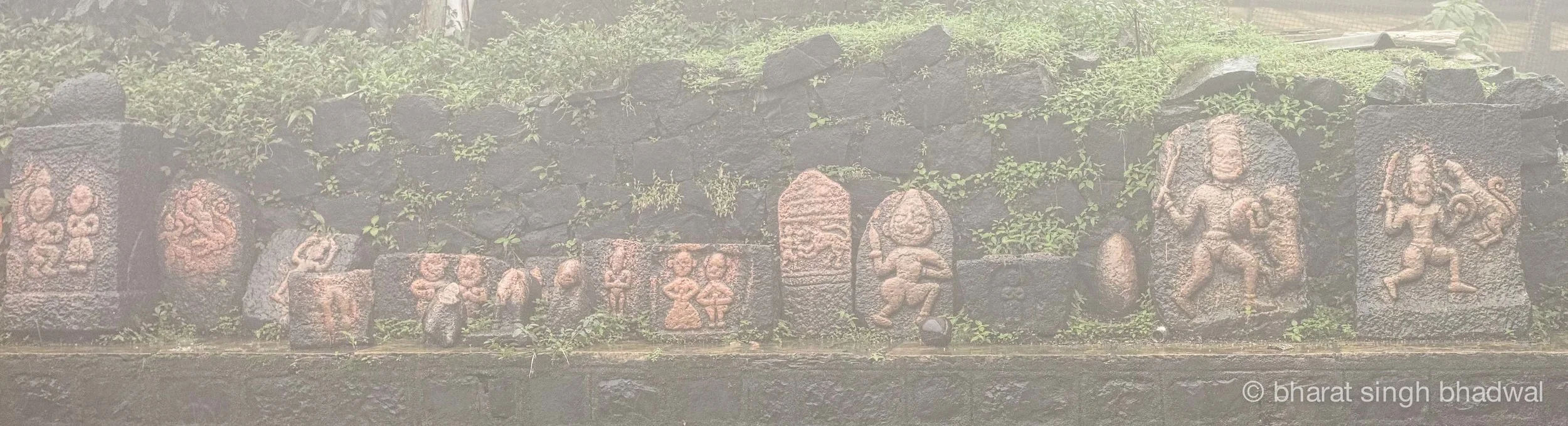 Historical idols at Kamalaja temple, viewed through the mist