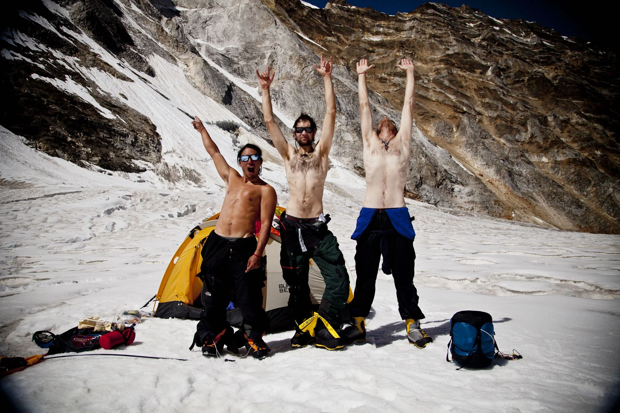 Jimmy Chin, Renan Ozturk and Conrad Anker rejoice after 12 days on the route. The descent is often the most dangerous part of climb. After two days of rappelling through severely overhanging rock, down rock strafed gullies and the final lower alpine ice wall, the team is finally able to take in their accomplishment. © Jimmy Chin from http://www.merufilm.com/