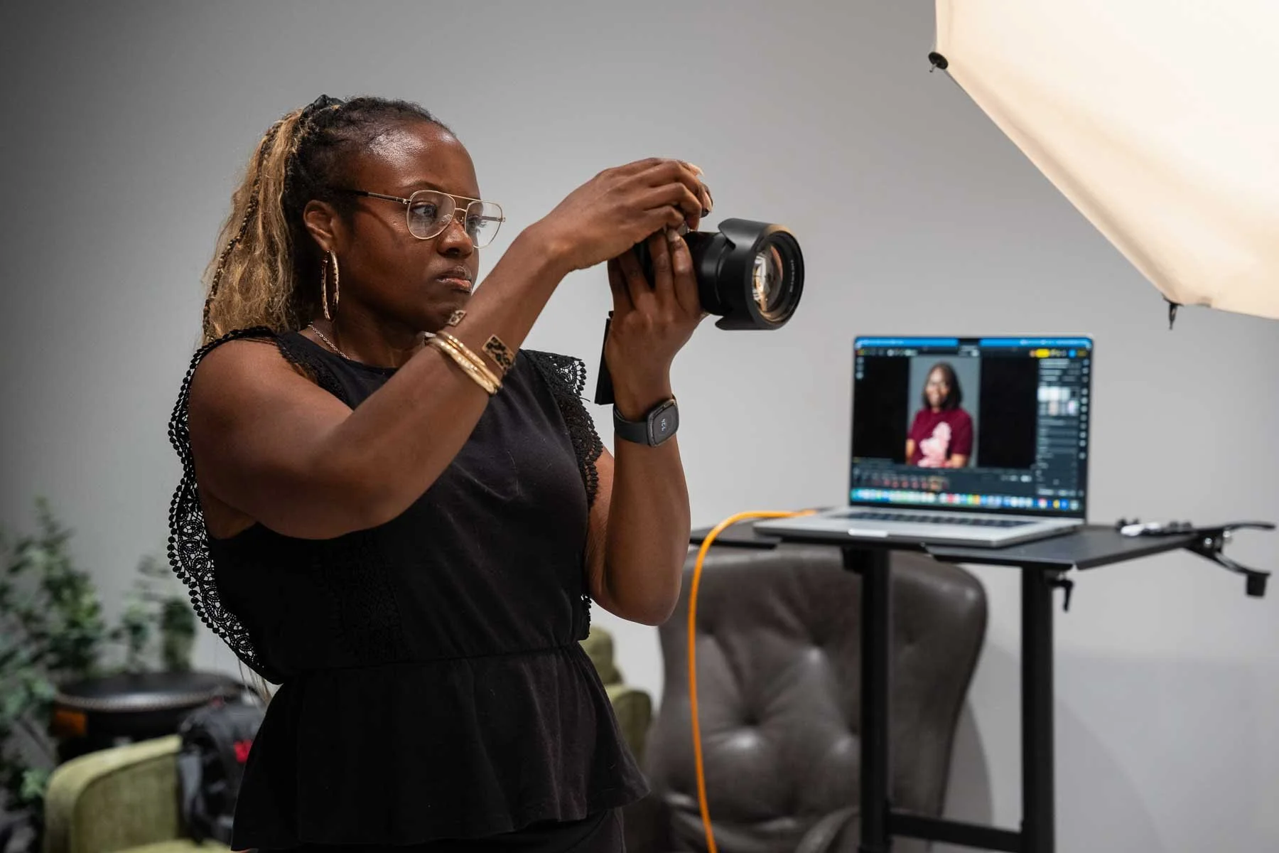 Photography student capturing professional headshots in a Winnipeg photography class using studio lighting, a laptop, and tethered shooting workflow.