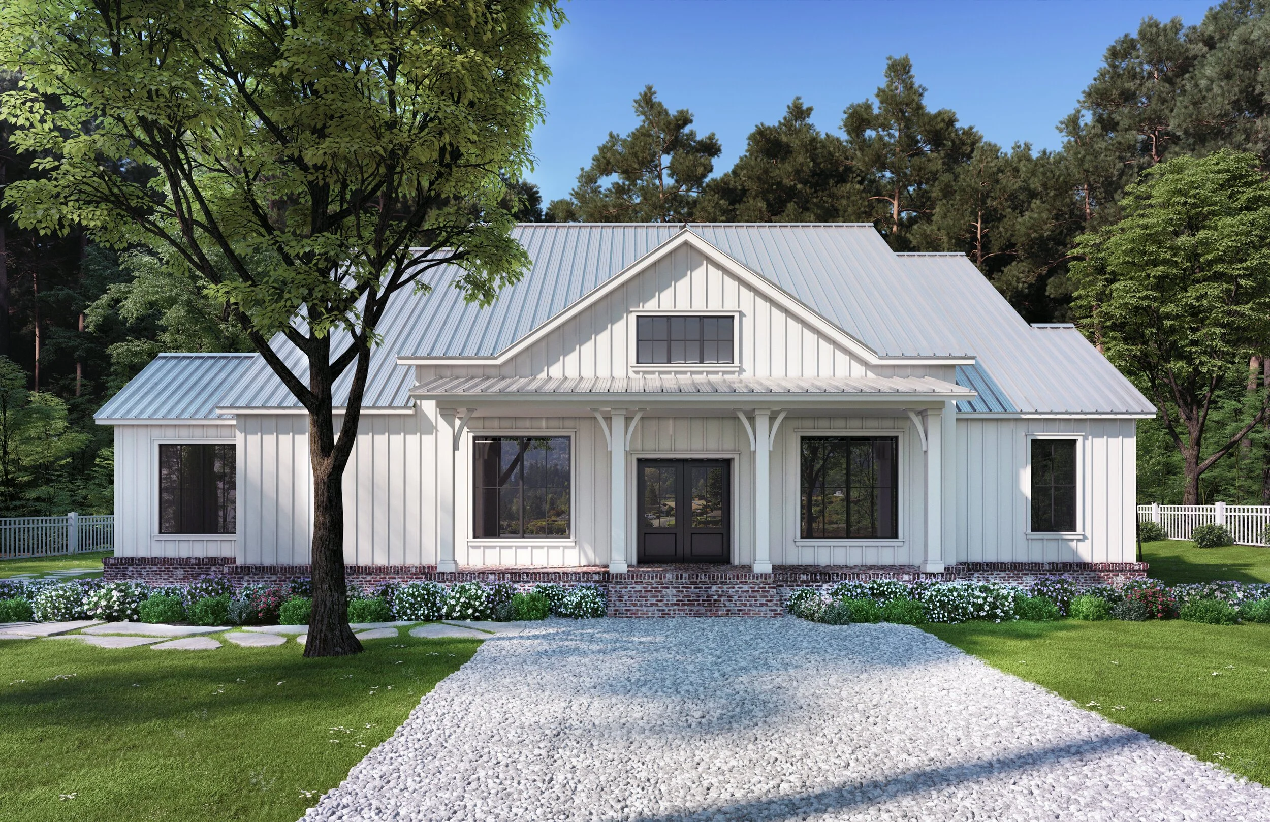 A white modern farmhouse with metal roof, large windows, front porch, surrounded by green lawn, trees, and flower beds, under a blue sky.