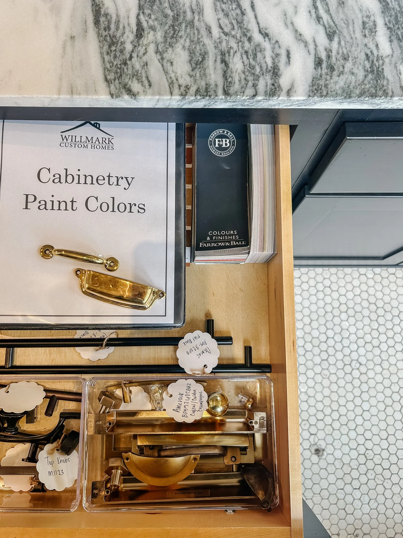 Display of cabinetry paint colors, hardware samples, and paint swatches at a store.