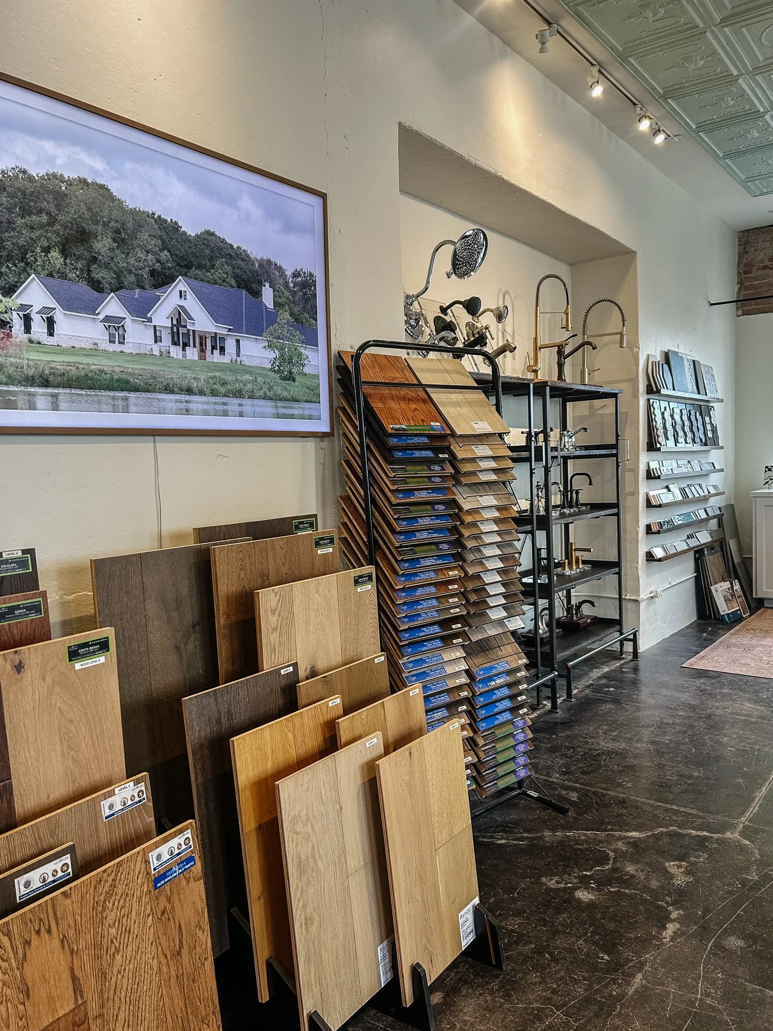 Display of hardwood flooring samples and kitchen fixtures in a showroom.