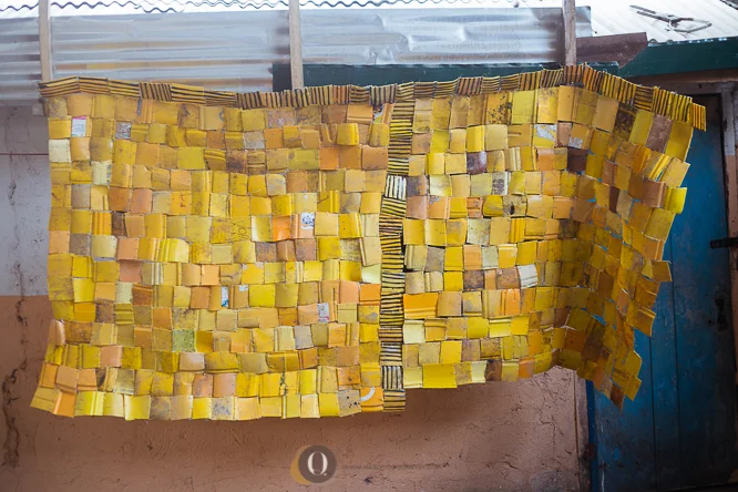 The building of an installation using cut up pieces of the yellow Kuffour gallons. 