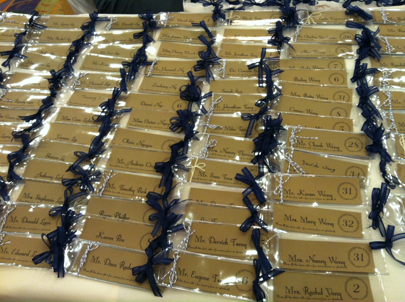 Escort cards with a multi-purpose/function. After guests take pictures at the photo booth, they can use these clear bookmark sleeves to keep all their photos from the night. How creative!