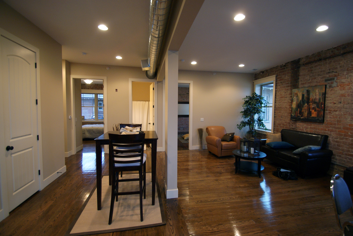 refinished hardwood floors, exposed brick wall and ductwork with large windows for natural light.jpg