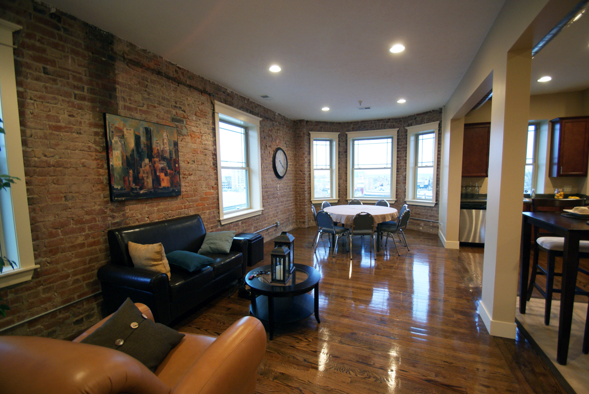 refinished hardwood floors, exposed ductwork and brick wall with large windows for natural light.jpg