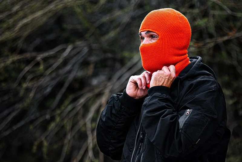 CUSTOM ROBBER MASK IN RAD ORANGE ON MAN IN BOMBER JACKET BY CAPTUER HEADWEAR.