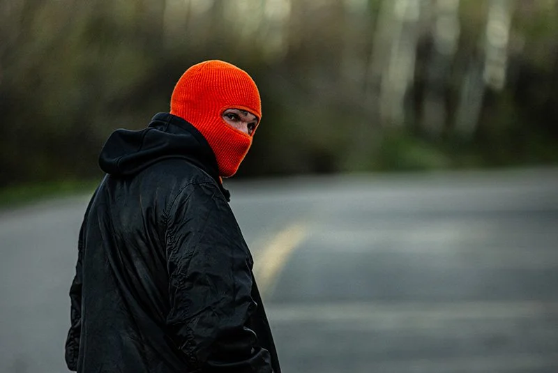CUSTOM ROBBER MASK IN RAD ORANGE ON MAN LOOKING BACK BY CAPTUER HEADWEAR.