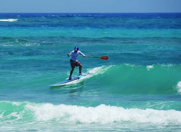Sup surfing a green wave at Glover's Reef, Slick Rock resort in Belize
