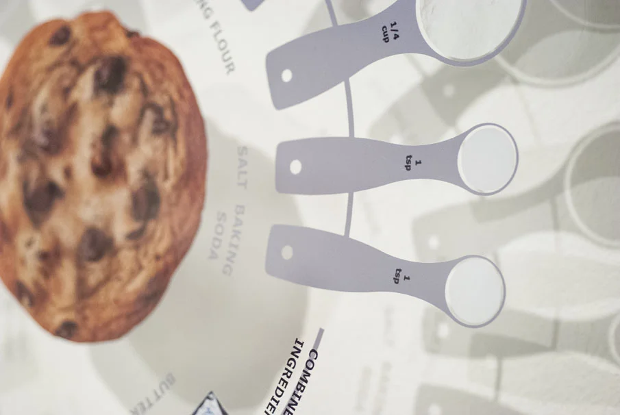 Cookie image, measuring spoon, and measuring cup graphics.