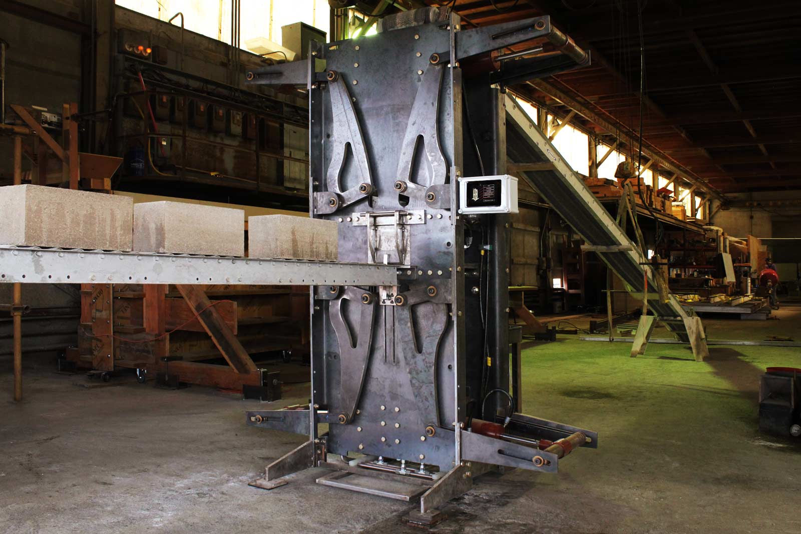High power in a small package. What sets the Watershed Materials block machine apart from the others is the Archimedean principle of compound force. “Give me a long enough lever and a place to stand and I could move the earth.” And it's not just brute force that squeezes grains into stone but smart force. Eight 4:1 lever arms multiply the compression energy of four four inch hydraulic rams working on two heavy steel platens, all teaming up to deliver 250 tons of force into each block.
