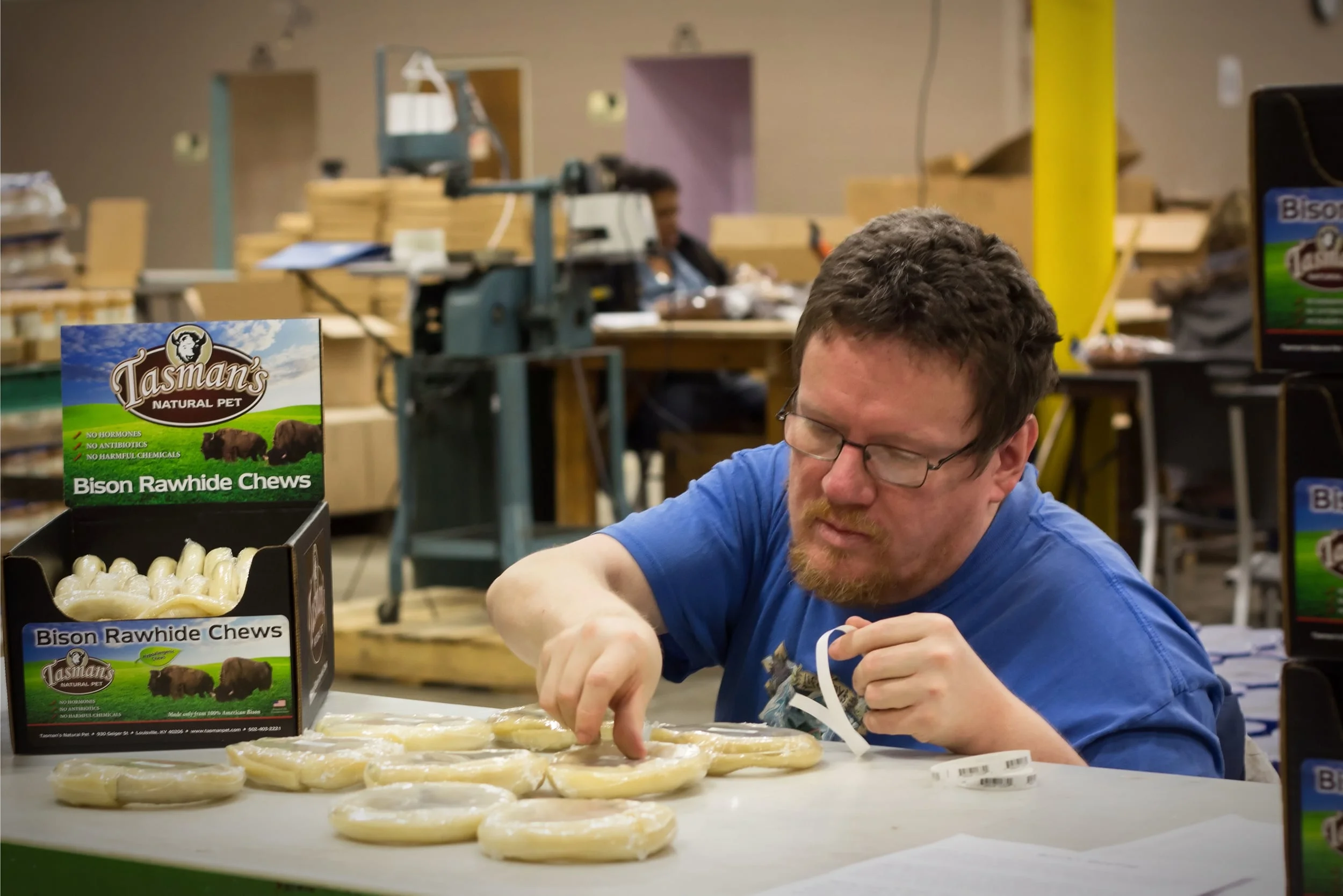 David, worker at Rauch Industries, labels Tasman Natural Pet products