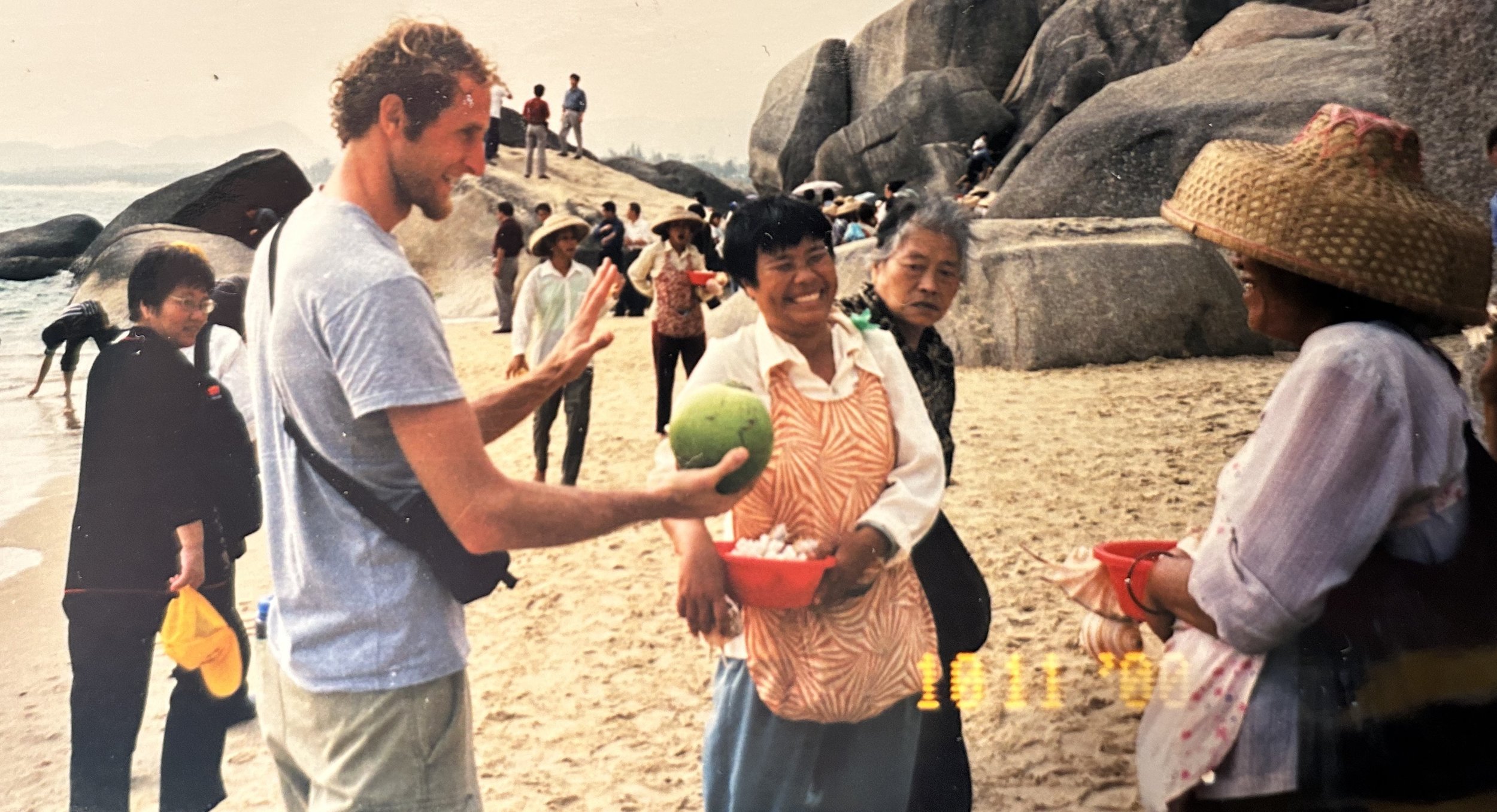 David, in Hainan, China, attempting to sell a coconut he found. The women were obviously a bit shocked he was speaking Chinese and also charging way below asking price.