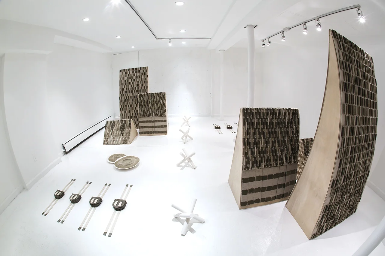 RUMOUR FROM GROUND CONTROL (exhibited from September 9 - October 18, 2015 at Rooster Gallery, Lower East Side, NYC) "This exhibition is a compilation of works relating to Lifanova’s progression between the years 2011 and 2015, during which time the artist traveled to and lived throughout Europe and Central Asia. The title borrows from David Bowie’s Ashes to Ashes, which reports on Major Tom, a figure introduced on an earlier album who travels to the far reaches of space in a tin can. This character’s solitary departure into unknown and uncharted territory runs parallel to Lifanova’s recent artistic journey, exploring new mediums and inventing startling new methods to create her work. The sculptures included in Rumour from Ground Control introduce intricate tensions between a sense of uncertainty and groundedness, held in balance by echos of the artist's previous series and ideas. Several pieces in the show can be traced to Lifanova’s Rolled series--delicately rolled pieces of paper, canvas or fabric arranged into patterned compositions--a body of work that first emerged in 2006. These works contribute to the rhythm of the exhibition, set by repeating units and symbols, and amplified by sculptures, installed in a yin-yang arrangement, setting up a kind of game between sameness and difference. Ceramic “chevaux de frise” (modeled after Czech hedgehogs, used as a defense in WWII), ceramic sticks and "flags" made of heavy parchment meters in lengths, further this play in opposites and contribute to the pretend quality of the objects as their function is unequivocally and undeniably compromised by both material and scale. In conflict with their implied military purpose, these sculptures, among others in her installation, oscillate between being an aerial view and a direct engagement with the spectator's body as each piece, scaled both up and down from its referent, measures itself against human proportions. Lifanova’s practice is fertile with contradictions, where the artist’s truth and its immediate refusal live side-by-side in a precise equilibrium held in balance by a predominance of control. The work’s martial aesthetic is often challenged by its fragile nature, thus imbuing these carefully crafted objects with a quality of humanness."