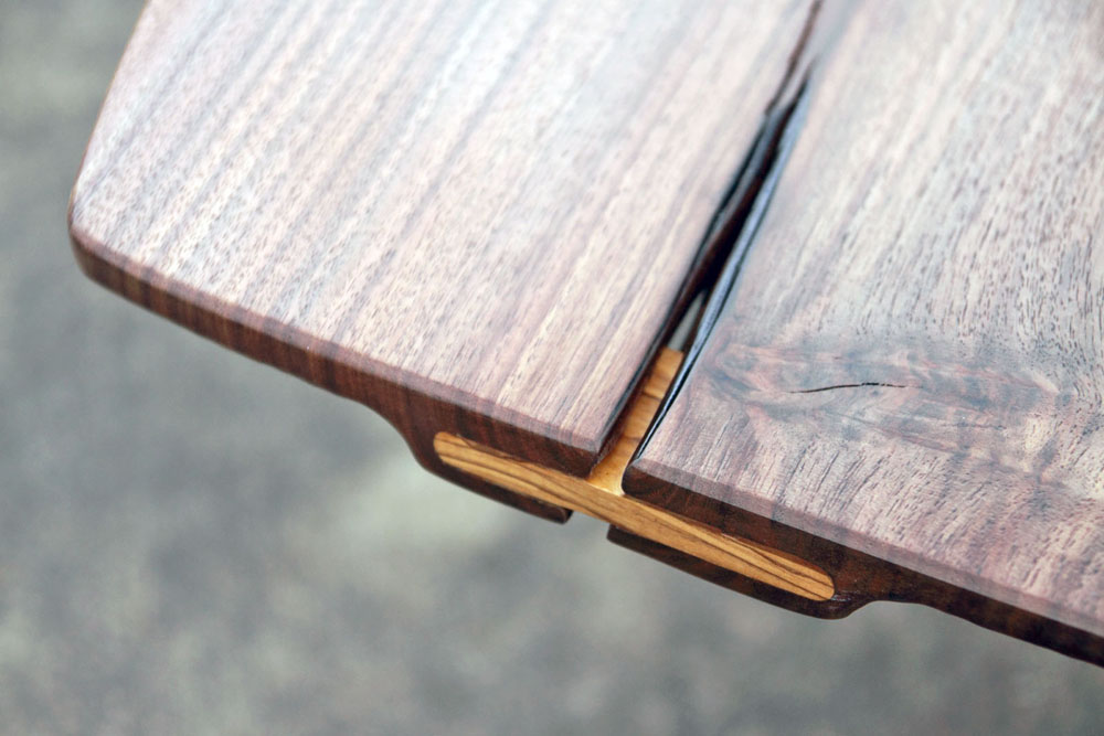 Three natural splits in the top are stabilized with Olive wood wedges. On either side of each wedge the top has been carved thin again to maintain the slender profile.