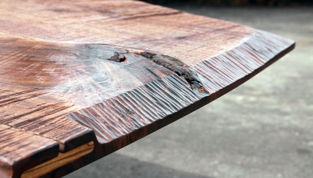 An inverted view of the tabletop. The original sawyer marks remain on the underside of the top. The transition from rough to smooth comes via the hand carved edges.